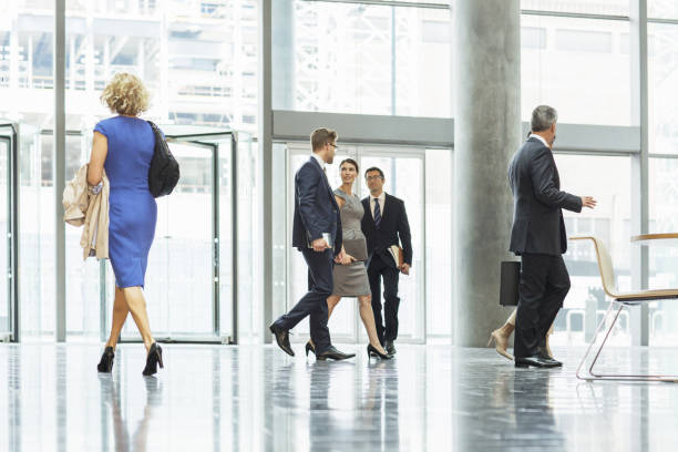 istock Business people walking in office lobby 457979399