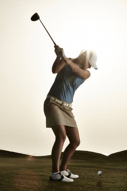 istock Woman swinging golf club 457979947