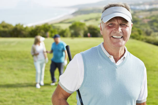 sonriente hombre mayor en el campo de golf - horizontal female with group of males posing looking at camera fotografías e imágenes de stock