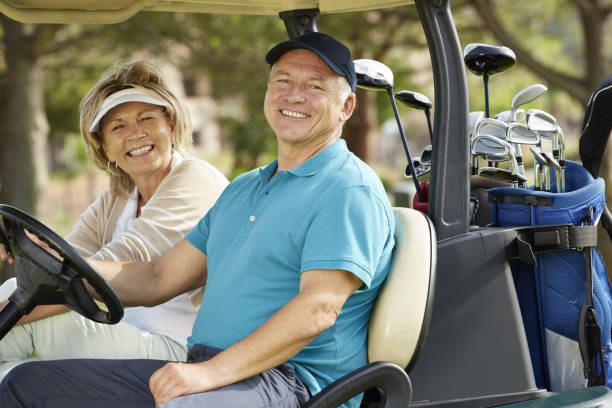 年配のカップル笑�顔でゴルフカート - golf cart golf bag horizontal outdoors ストックフォトと画像
