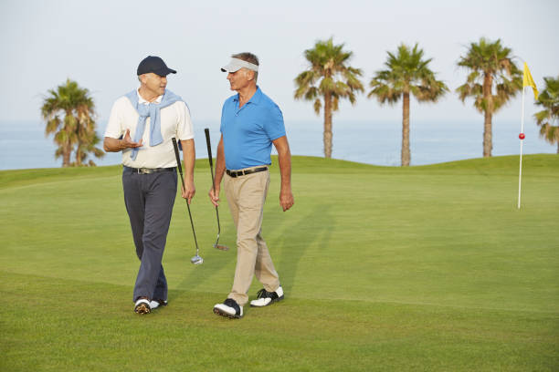 homens idosos a caminhar no campo de golfe - baseball cap cap hat golf hat imagens e fotografias de stock