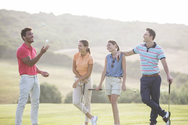 amigos de malabarismo bolas de golfe no campo de golfe - golf four people young adult playing imagens e fotografias de stock