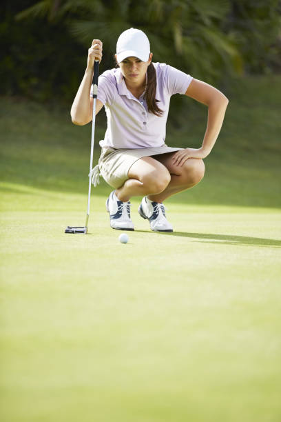 woman preparing to putt on golf course - golf women female concentration 뉴스 사진 이미지