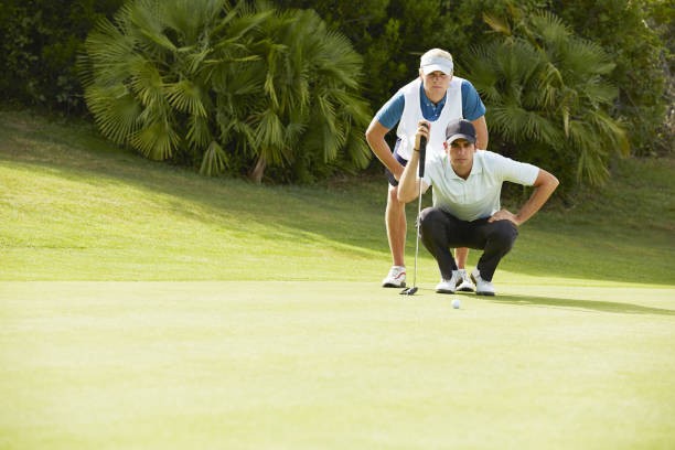 carro y golfista preparando para putt - caddy fotografías e imágenes de stock