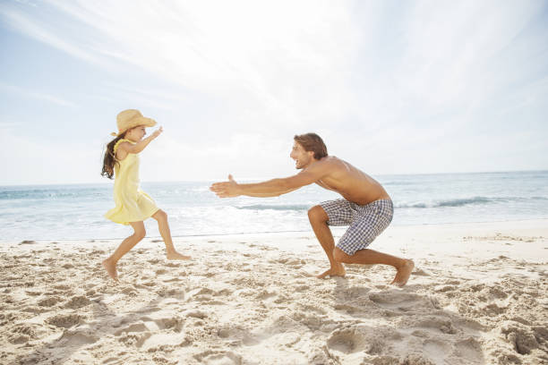 padre e figlia che giocano sulla spiaggia - men beach running shirtless foto e immagini stock