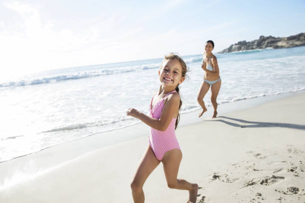istock Mother and daughter running on beach 457980595