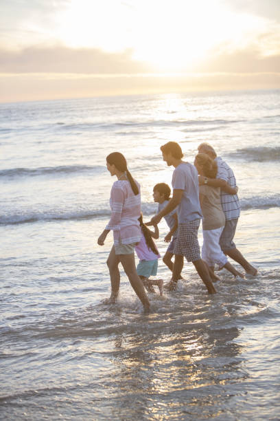 multi geração família andar no surf na praia - ankle deep in water imagens e fotografias de stock