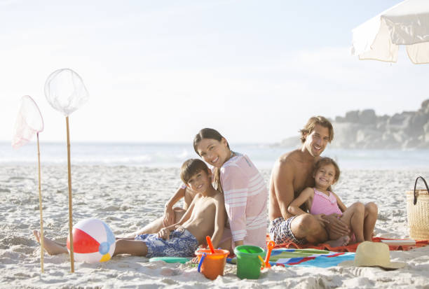 istock Family relaxing together on beach 457980707