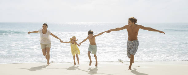 istock Family running together on beach 457980711