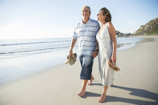 istock Senior couple walking on beach 457980723