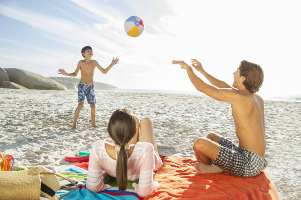 istock Family playing together on beach 457980839