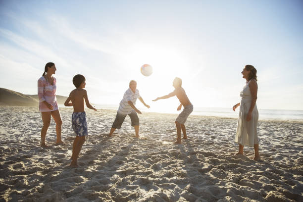 istock Multi-generation family playing volleyball on beach 457980843