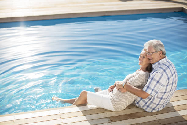 istock Senior couple relaxing by pool 457980863