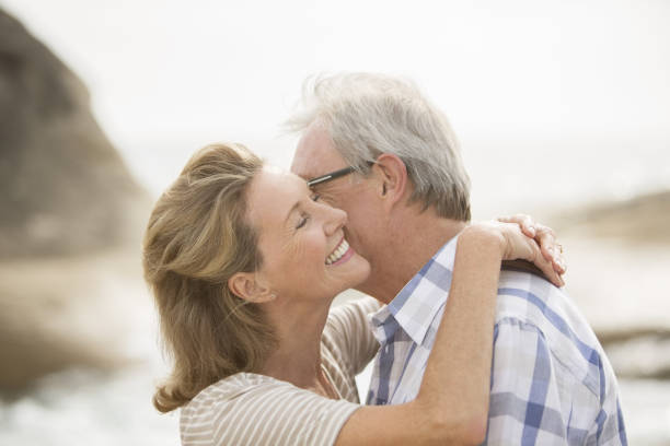 istock Older couple kissing on beach 457980959