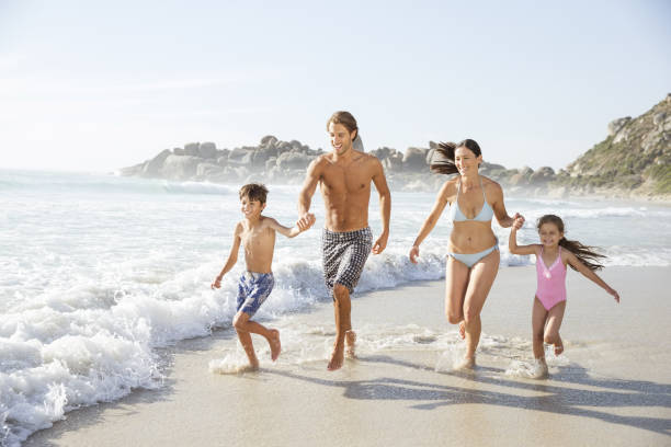 istock Family running together in waves 457980973
