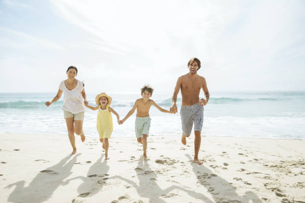 istock Family running together on beach 457980993