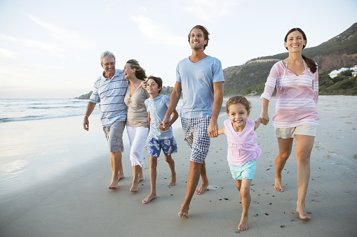 Cheerful Family and happy cute little daughter walk by the sea, enjoy the sea view and play together on vacation.
