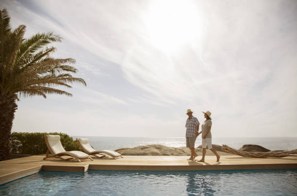 istock Older couple relaxing together by pool 457981611