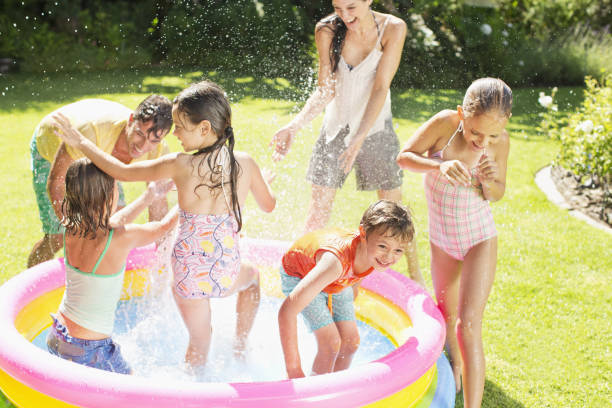 istock Family playing in paddling pool in backyard 457981843