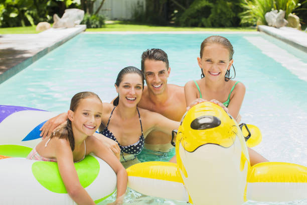 istock Family swimming in pool together 457981963