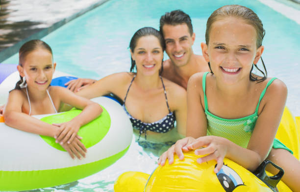 istock Family swimming together in pool 457981971