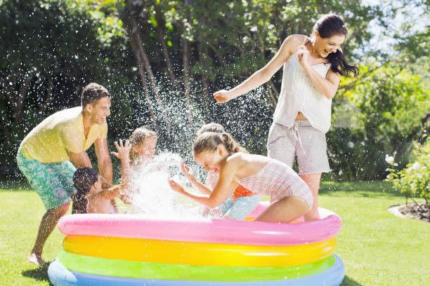 istock Family playing together in wading pool 457982087