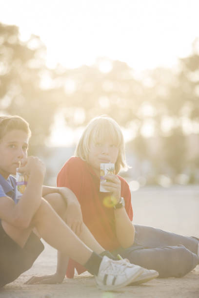 Happy boy talking whit his little sister while sitting in public park