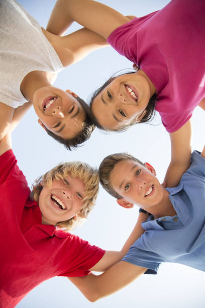 istock Low angle view of children smiling in huddle 457984357