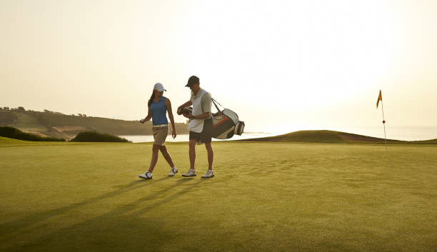 carro y mujer caminando por un campo de golf con vista al mar - golf course usa scenics sports flag fotografías e imágenes de stock