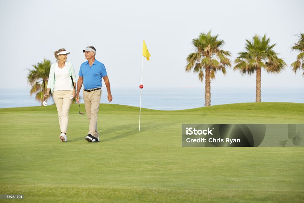 Senior couple walking on golf course  Golf Stock Photo