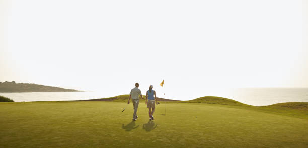 couple playing golf on course - golf panoramic golf course putting green 뉴스 사진 이미지