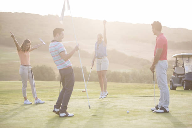 entusiasta amigos no campo de golfe - golf four people young adult playing imagens e fotografias de stock