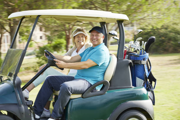 istock Senior couple driving golf cart on course 457984821