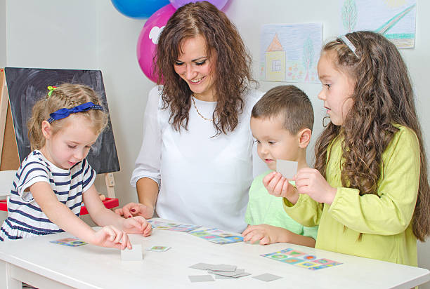 istock Teacher plays with children in kindergarten. 458005595