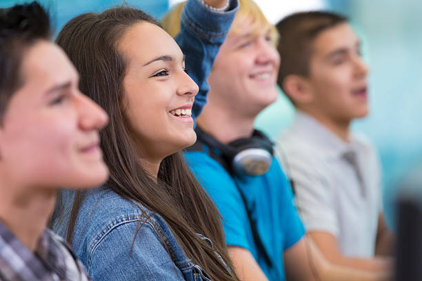 istock High school student raising hand to answer question in classroom 458060463