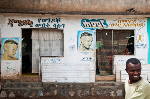 Arba Minch, Ethiopia - August 7, 2010:An Ethiopian man walks past a barbershop in the southern Ethiopian town of Arba Minch, located about 500km south of the capital, Addis Ababa.