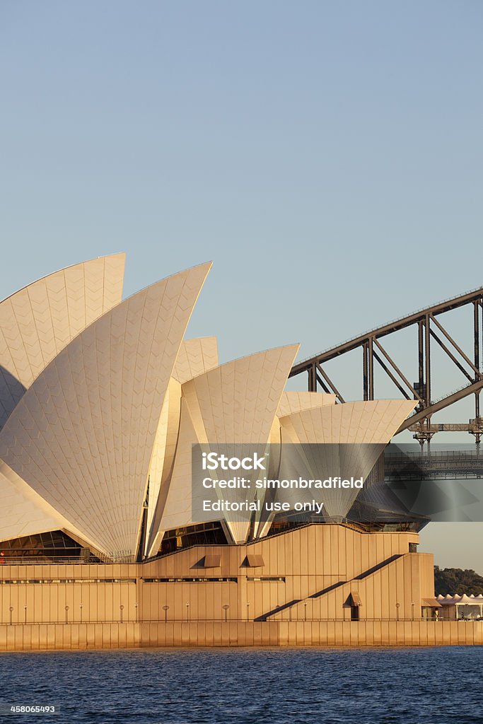 Sydney Harbour Landmarks "Sydney Australia - August 17, 2009: Early morning sunlight lights up two of Australia\'s great icons, the Sydney Opera House and, in the background, the Sydney Harbour Bridge." Architecture Stock Photo