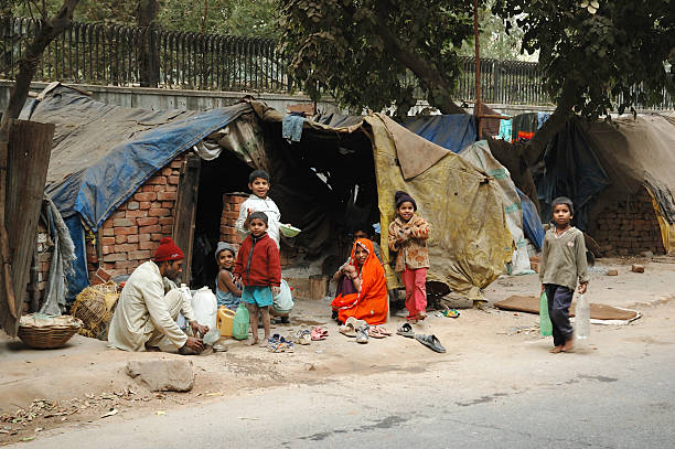 Poor family at slum area "Delhi,India - December, 12th,2007: Poor family at slum area,millions people of India doesn\'t have normal housing because of overcrowding problem" india poverty stock pictures, royalty-free photos & images