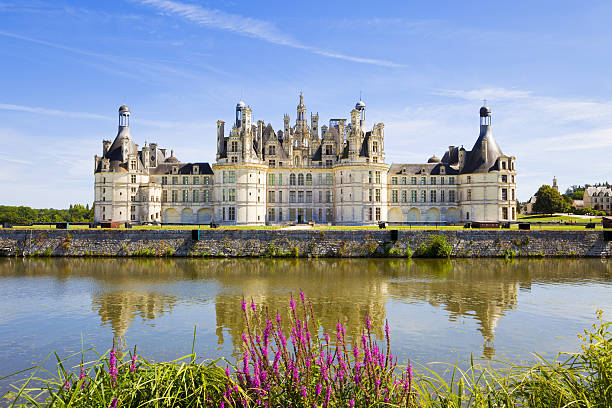 Chambord chateau panoramic from the canal "Chambord, France - July 31, 2009: Great panoramic of Chambord Chateau reflected in the canal in a summer day with blue sky. There are some unrecognizable people in the balconies" loire valley photos stock pictures, royalty-free photos & images
