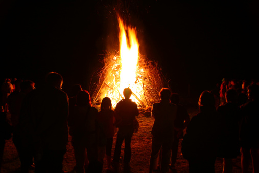 Rignat, France - June 23, 2012: group of people seen from behind, watching a bonfire for the Feast of St. John, bonfires lit on Midsummer Night