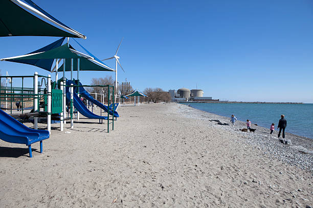 Playground at the beach "Pickering,Canada - March 19,2011:A playground at the beach of Lake Ontario near the Pickering nuclear power station,a mother with three kids and pets play there,near Toronto,Ontario." sustainable energy toronto stock pictures, royalty-free photos & images