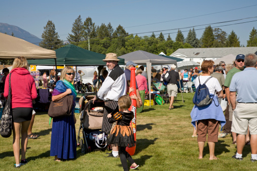 Windermere,British Columbia,Canada - September 10,2011: Group of adults and children at the Twelfth Annual Fall Fair and Scarecrow Festival in Windermere British Columbia. Several Kiosks in background selling handcrafted goods. 