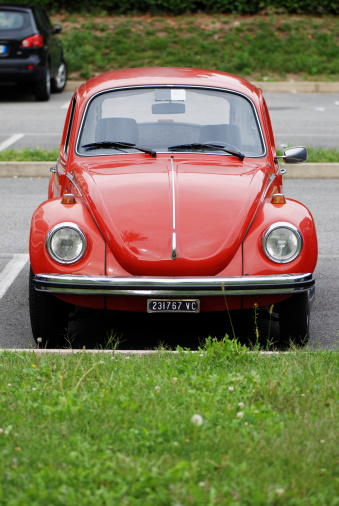 Borgosesia, Italy - September 19, 2011: Old red Volkswagen Beetle model VW 1303 parked in a parking lot in Borgosesia, front view.