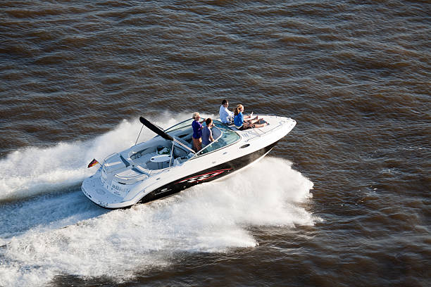 Luxury yacht sailing at high speed on the sea, with water splashing and clear blue sky. Concept of leisure, adventure, travel, freedom, and lifestyle.