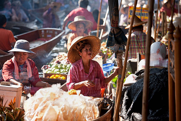 fornitori di frutta al mercato galleggiante di damnoen saduak, tailandia. - editorial horizontal farmer occupation foto e immagini stock