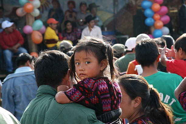 petits curieux maya fille avec ses parents dans chichicastenango, guatemala - mother family vertical flower photos et images de collection