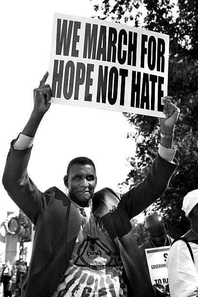 Man holding up protest sign "Washington D.C., USA - October 2, 2010. A man holds up a protest sign that reads \""We March for Hope not Hate\"". Photo was taken at the One Nation March, a rally for union and civil rights." civil rights stock pictures, royalty-free photos & images