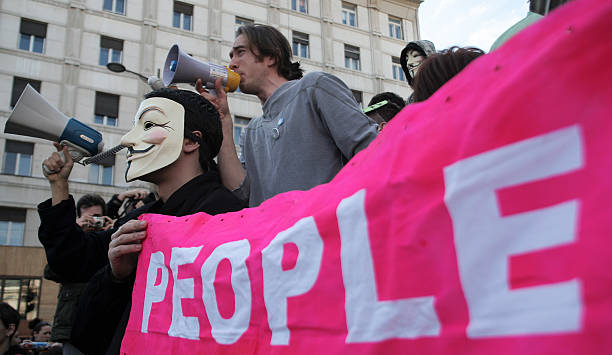 protesta con persone banner - anonymous rete di attivisti foto e immagini stock