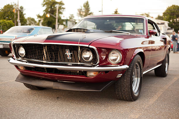 Classic 1969 Ford Mustang Mach 1 "Dartmouth, Nova Scotia Canada - July 19, 2012: A 1969 Ford Mustang Mach 1 antique car in Dartmouth, Nova Scotia, Canada. This classic car was parked by the owner in a parking lot at a local evening gathering with other classic cars, which can be seen in the background." porsche classic sports car obsolete stock pictures, royalty-free photos & images