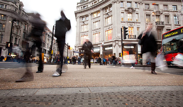 Shopping on Oxford Street, London. "London, UK - December 22, 2010: Long exposure blurring the movement of the crowds crossing through London's Oxford Circus during a grey, overcast winters day." long exposure winter crowd blurred motion stock pictures, royalty-free photos & images